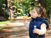 Symbolfoto Kind mit Seifenblasen